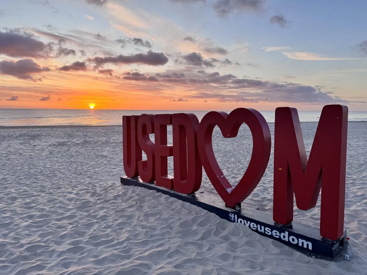 USEDOM lettering on the beach at sunset